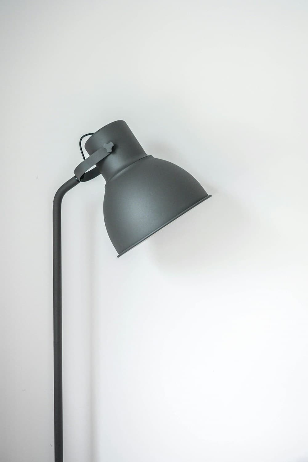 Skulptural golvlampa i matt grafit med vinklad skärm